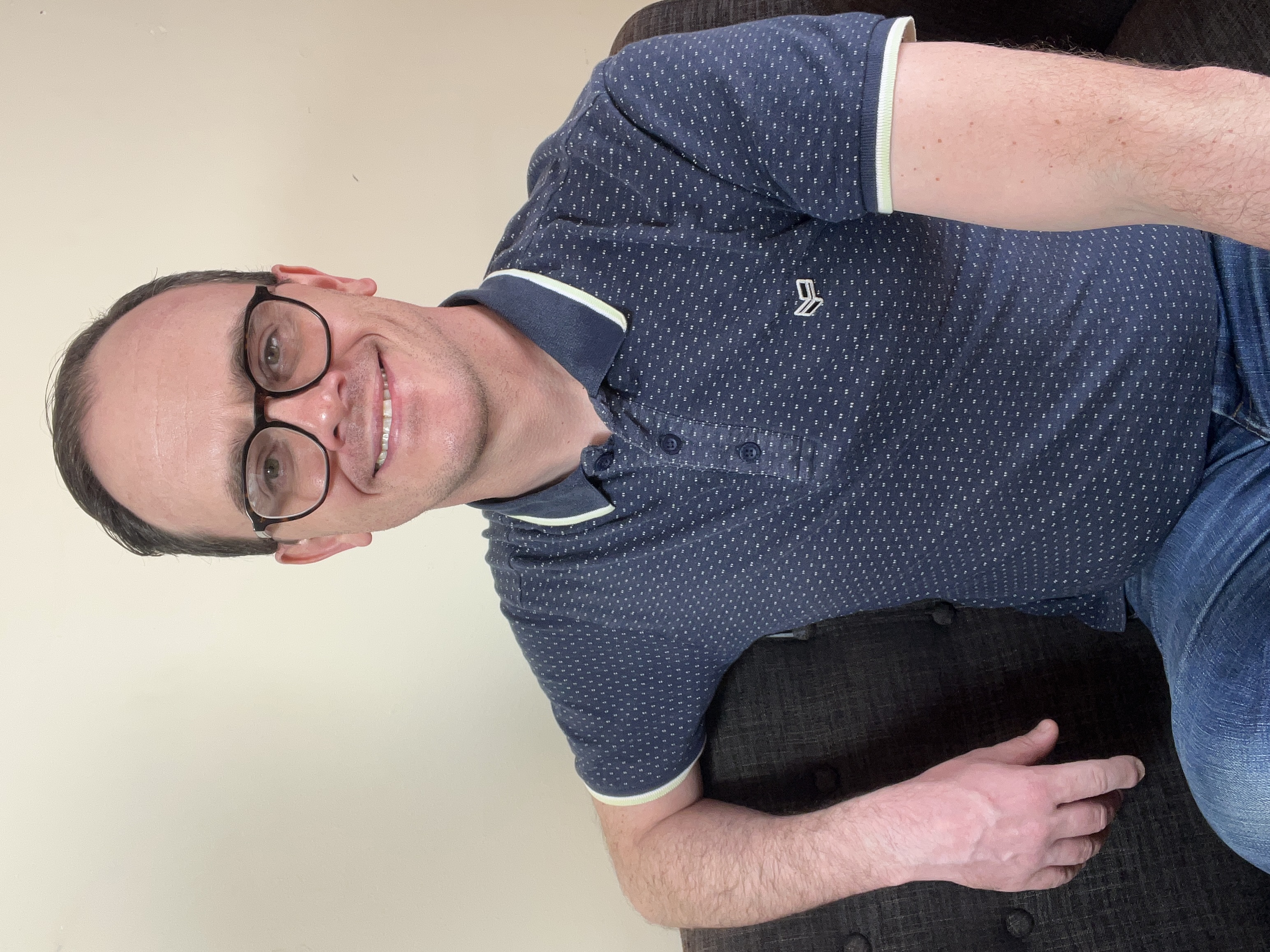 Max relaxing on a sofa and smiling